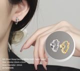 Silver and gold hoop earrings worn by a person, with close-up inset showing details.