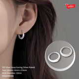 Silver hoop earrings worn by a person with an inset showing the earrings' design.