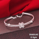 A silver bangle bracelet with a textured rope-style band and a central four-leaf clover charm, displayed on a dark patterned box with red fabric in the background. White text in the bottom right corner reads '99AB145 8.